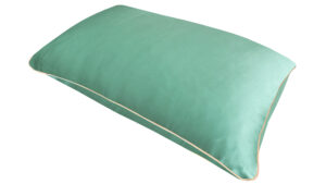 Jade silk pillowcase with honey-coloured piping on a white background