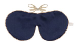 A navy blue silk sleep mask with gold edging and honey ribbon ties