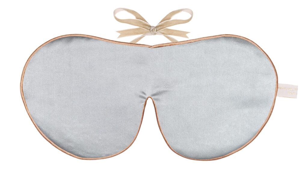 Silver silk sleep mask with honey colour piping and a ribbon tie